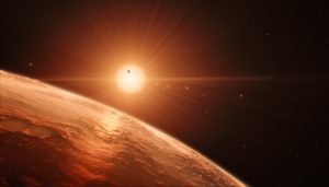 This artist’s impression shows the view from the surface of one of the planets in the TRAPPIST-1 system. At least seven planets orbit this ultra cool dwarf star 40 light-years from Earth and they are all roughly the same size as the Earth. They are at the right distances from their star for liquid water to exist on the surfaces of several of them. This artist’s impression is based on the known physical parameters for the planets and stars seen, and uses a vast database of objects in the Universe.